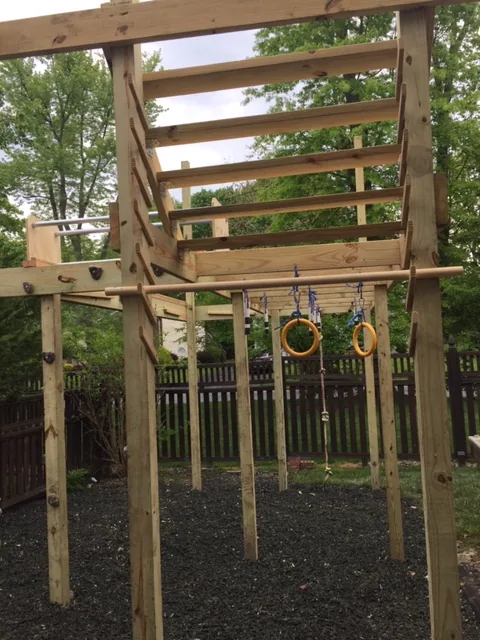 Customer-built backyard obstacle course with hanging rings and bars
