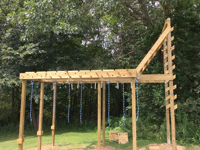 Customer-built wooden backyard obstacle course with hanging grips and a salmon ladder